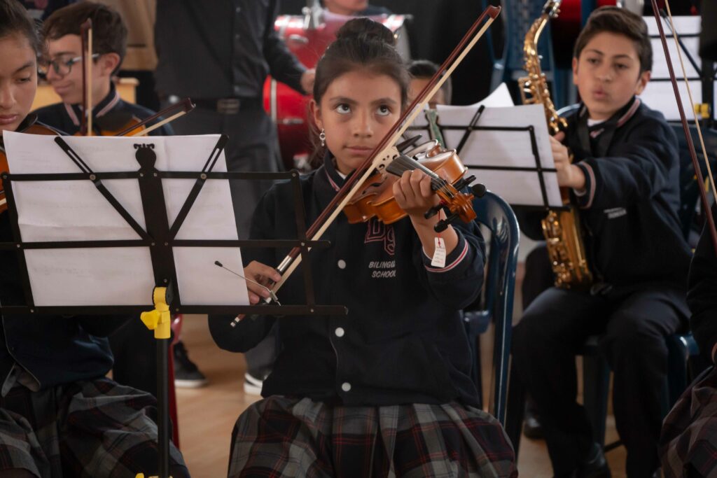 Estudiantes interpretando violín en una muestra musical