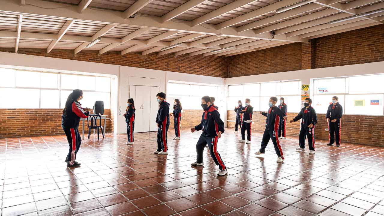 Estudiantes en aula múltiple durante actividad corporal y artística