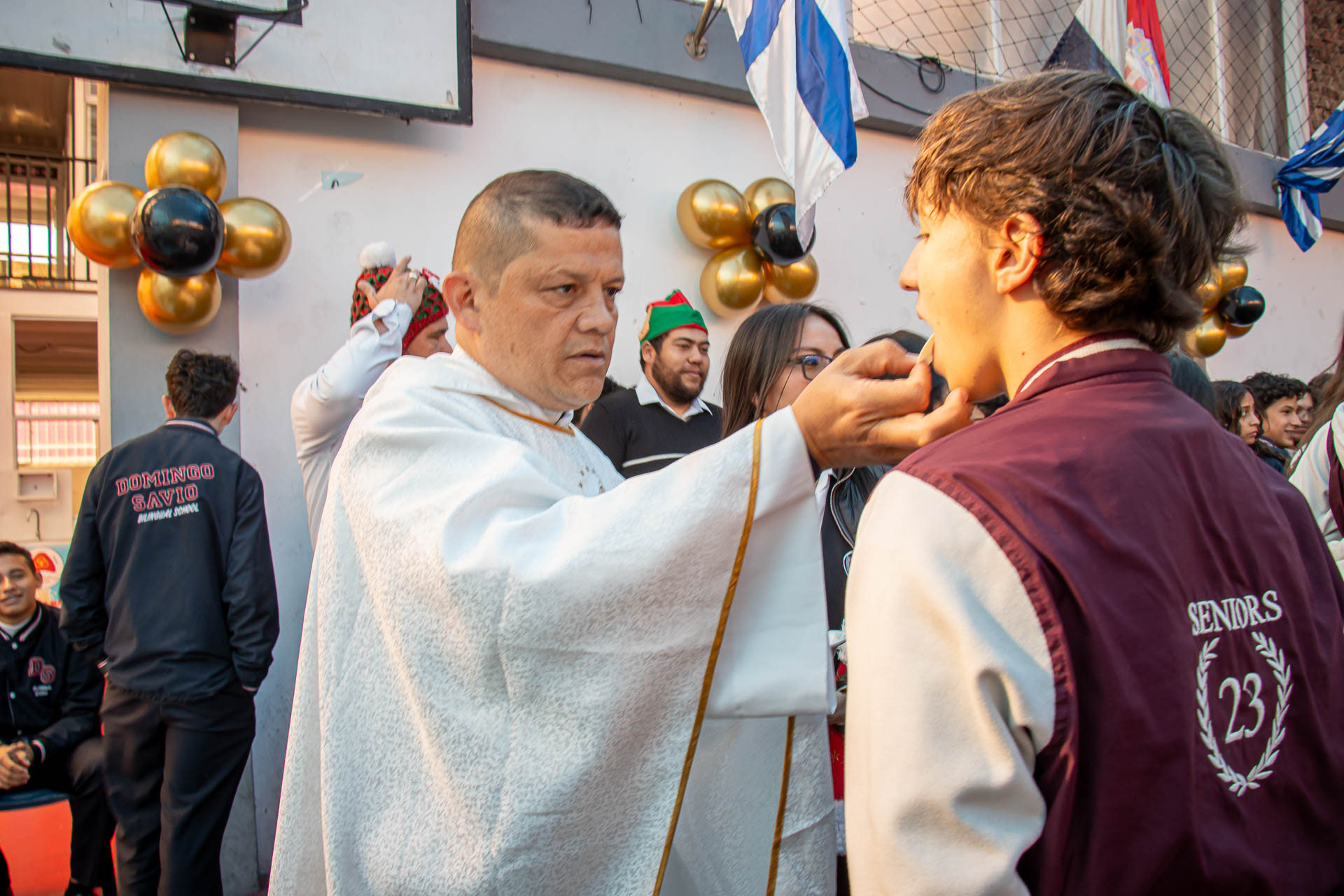 Sacerdote acompañando a un estudiante durante una celebración pastoral.