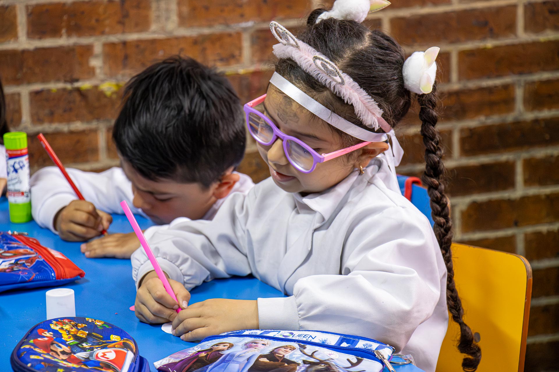 Estudiante de preescolar escribiendo en su cuaderno