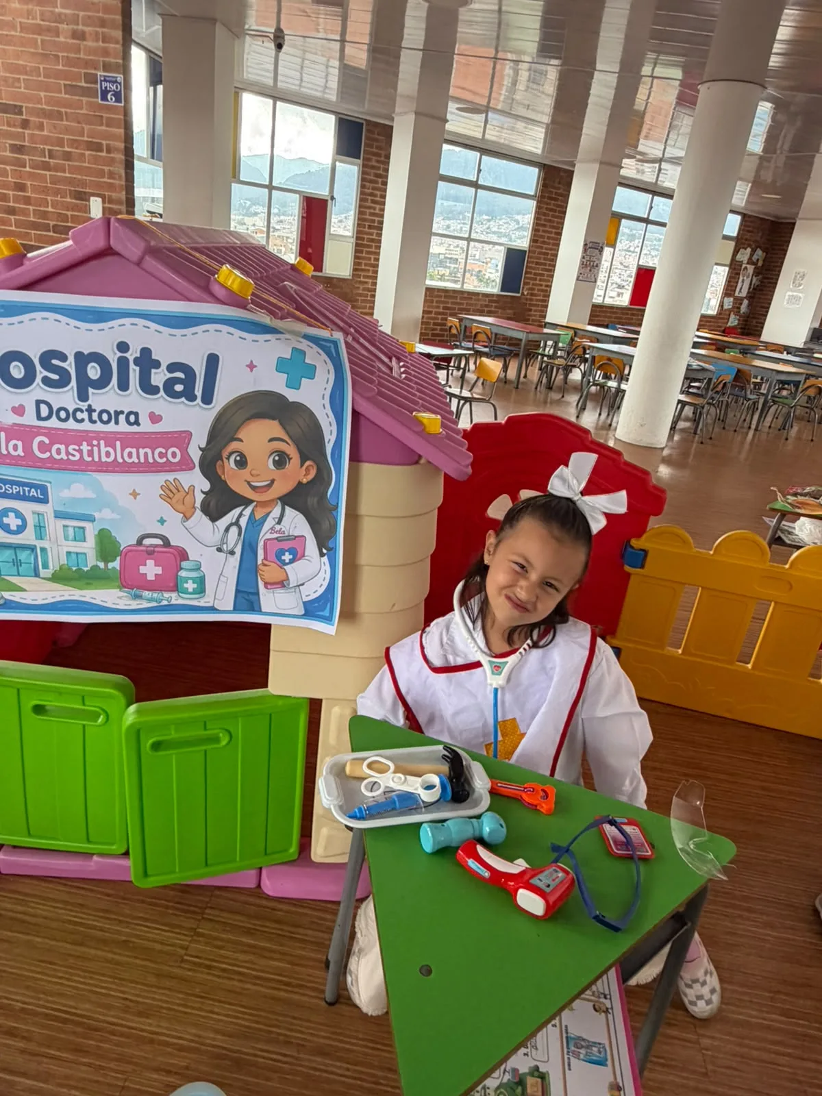 Niña de Preschool representa una profesión de la salud en el hospital de SaviCity.