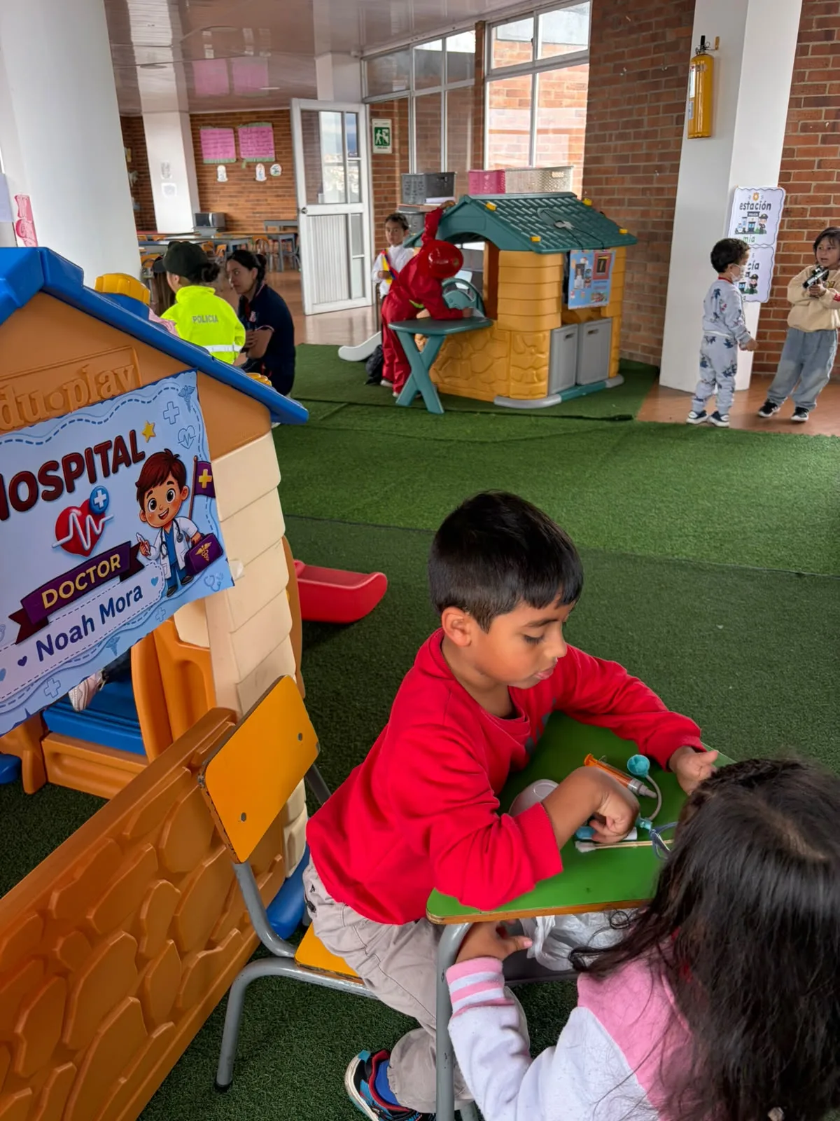 Niños de Preschool participan en el hospital de SaviCity mediante juego simbólico.