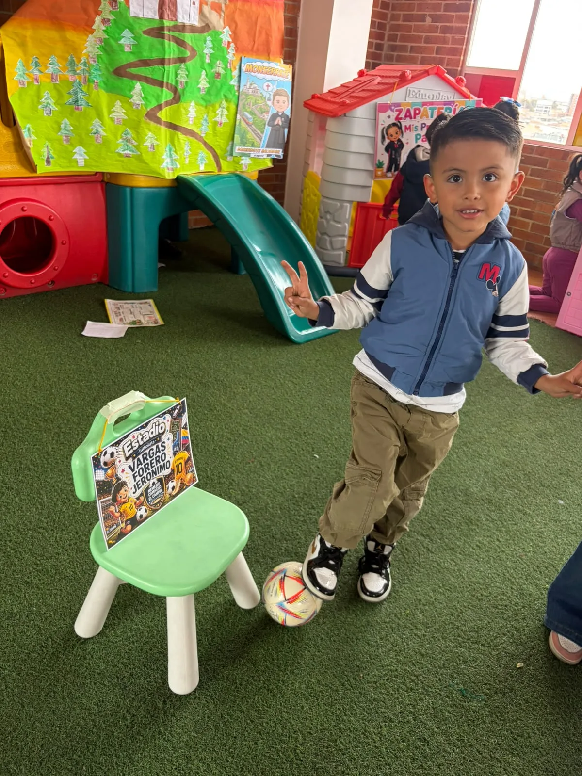 Niño de Preschool explora las estaciones de estadio y zapatería durante SaviCity.