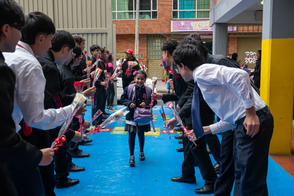Estudiante recibe flores durante la conmemoración del Día de la Mujer en el Domingo Savio Bilingual School.